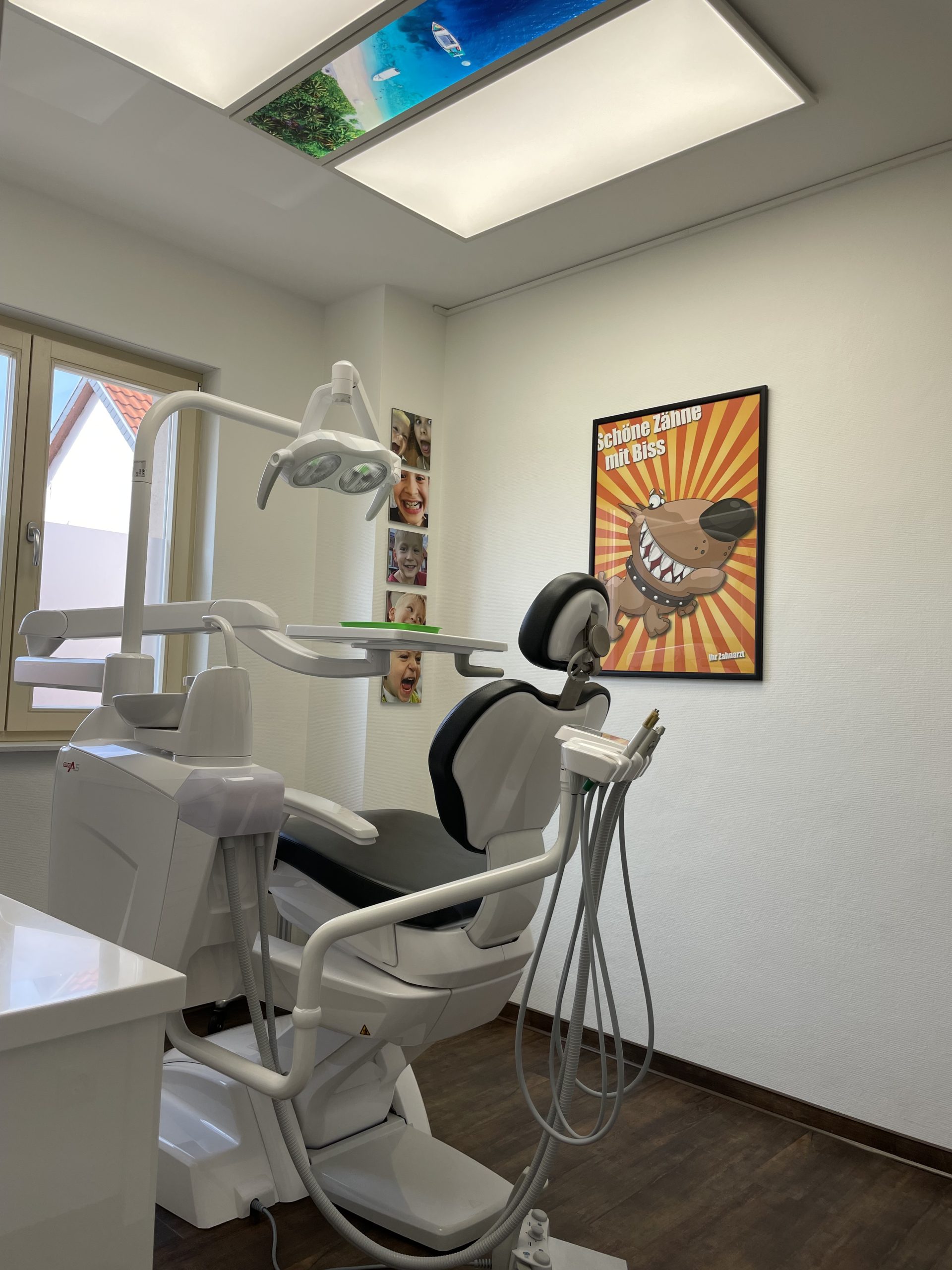 Moderner Behandlungsraum der Kieferorthopädie-Praxis in Stendal mit einem stilvollen Behandlungstuhl und einem bunten Cartoon-Poster an der Wand.